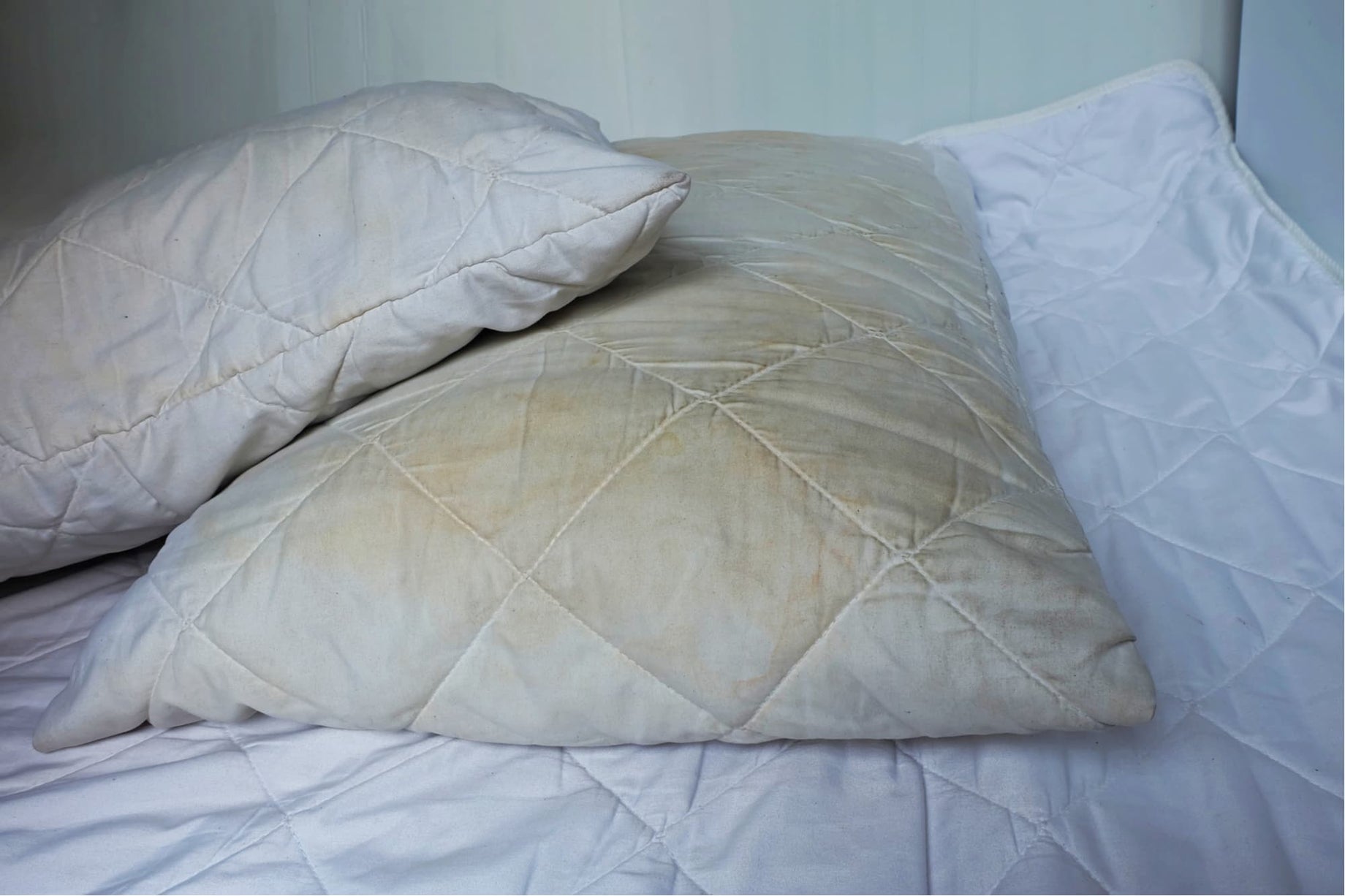 Old, dirty pillows on bed